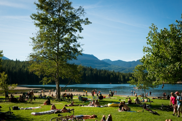 Relaxing on the beach at Lost Lake on a sunny summer day in Whistler.